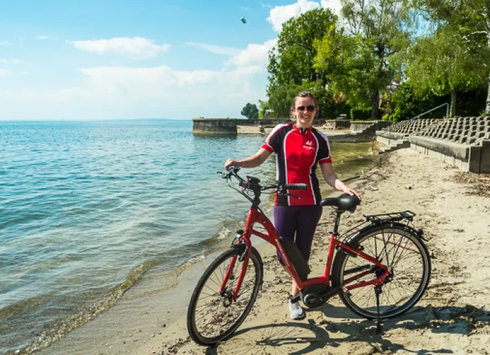 Sarah with the e-bike on the shores of Lake Constance